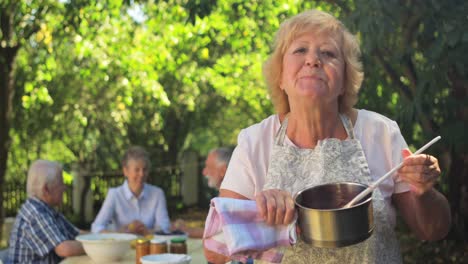 Senior-woman-tasting-jam-in-garden
