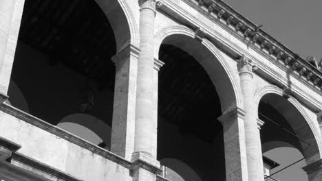 fotografía en blanco y negro del palacio venecia desde abajo en roma, italia durante el día.