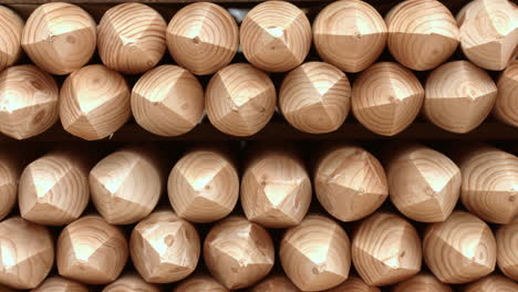 wooden sharpened logs are in rows in warehouse. processed logs in warehouse