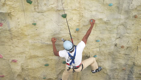 one man is playing wolltopia rock climbing walls game on a cruise in singapore