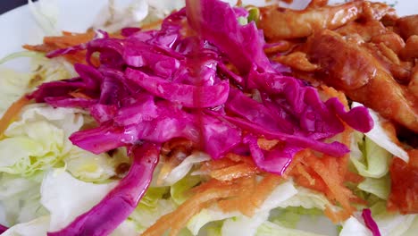 close view of hand pouring sauce salad on table