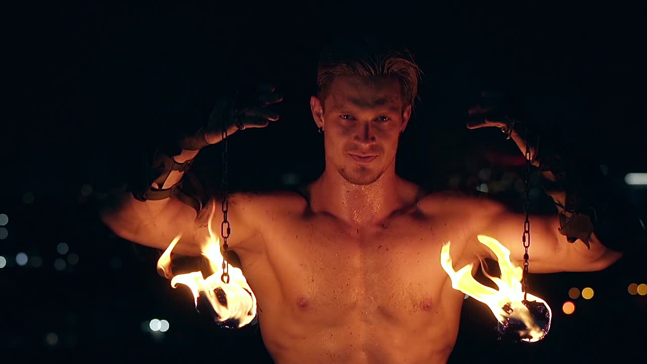 젊은 금발 남자가 두 마리의 포를  ⁇ 사슬에 매달고 남자가 카메라를 쳐다보고 슬로우 모션  ⁇  클로즈업  ⁇ 을 찍습니다.