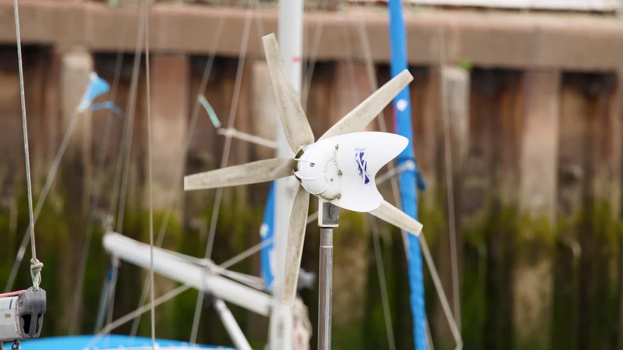 Close-up of wind turbine spinning on sailboat, overcast daylight, shallow depth of field, static shot