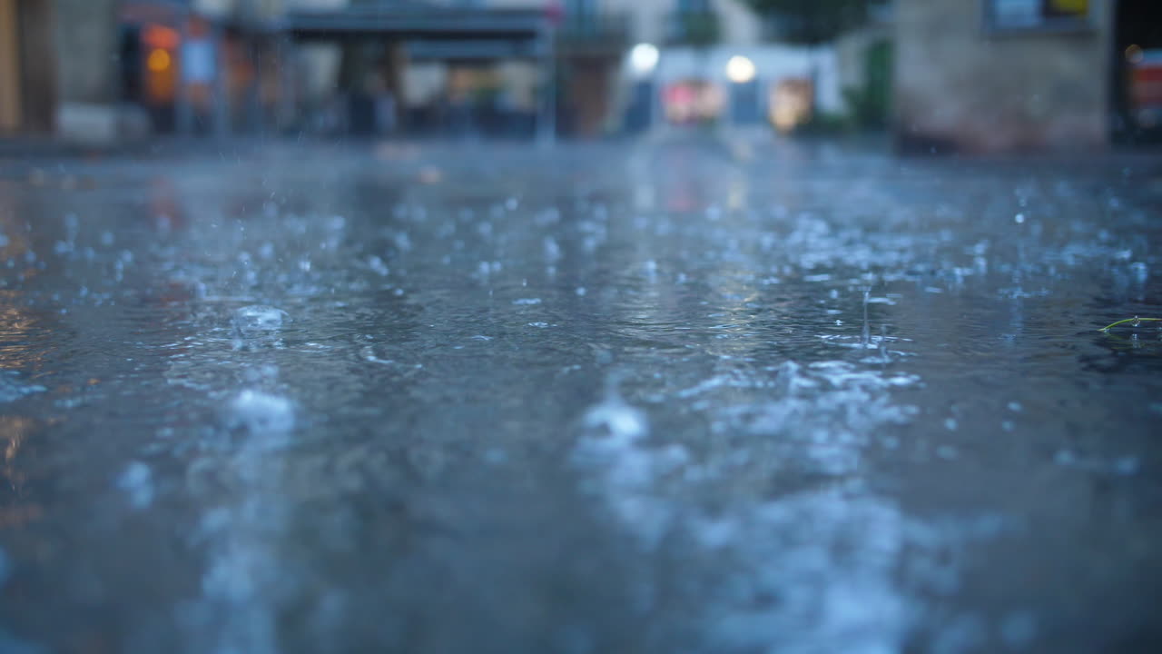 Rain drops in Montpellier streets close up view France slow motion