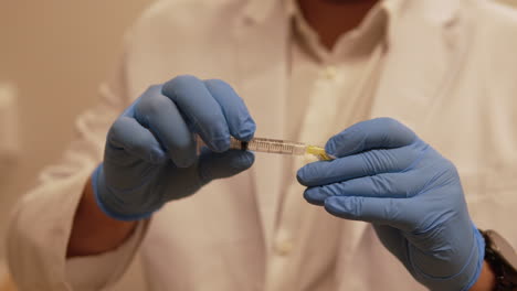 un profesional médico prepara una jeringa para su uso, demostrando cuidado y precisión en las prácticas médicas y destacando la importancia de la seguridad en los tratamientos médicos