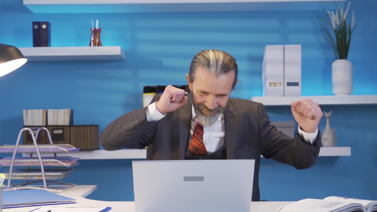 зрелый бизнесмен, счастливо радующийся успеху в бизнесе.