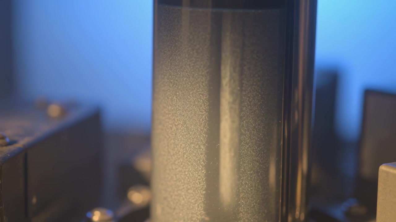 Showing cylindrical glass vacuum tube glowing on workbench, with power ramping, socket, chassis
