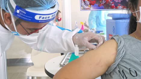 Woman-With-Face-Mask-Getting-Vaccinated-In-A-Public-Hospital-In-Phnom-Penh,-Cambodia---Coronavirus,-Covid-19-and-Vaccination-Concept---close-up