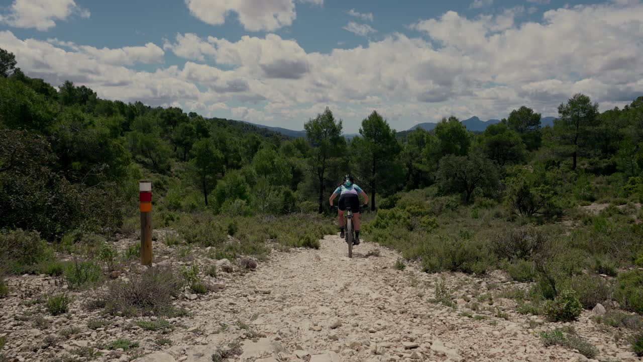 Mulher ciclista de mountain bike em trilha florestal downhill