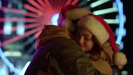 affectionate couple hugging outdoor. man and woman enjoying christmas night.