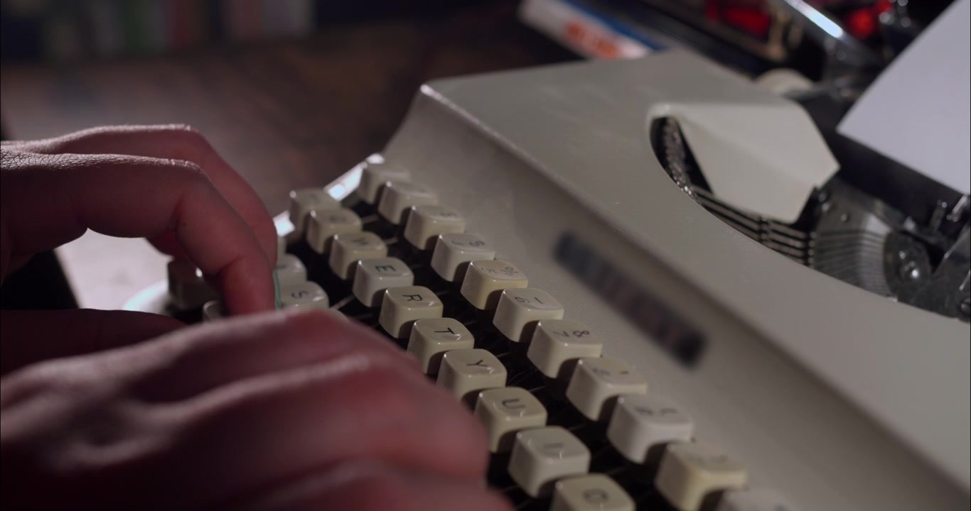 Primo piano di mani che digitano su una macchina da scrivere manuale d'epoca
