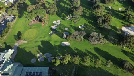 Inclinación-Aérea-Hacia-Abajo-Que-Muestra-Un-Campo-De-Golf-Con-Arena-Y-árboles-Durante-El-Día-Soleado-En-Perth.