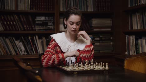 woman playing chess in a library