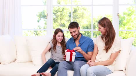 cute girl giving present to father