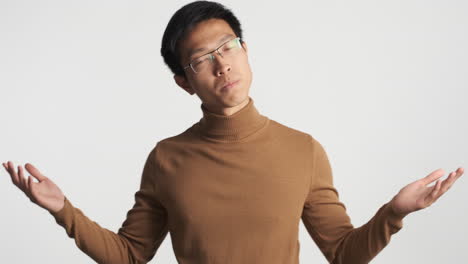 asian man showing i don't know gesture.