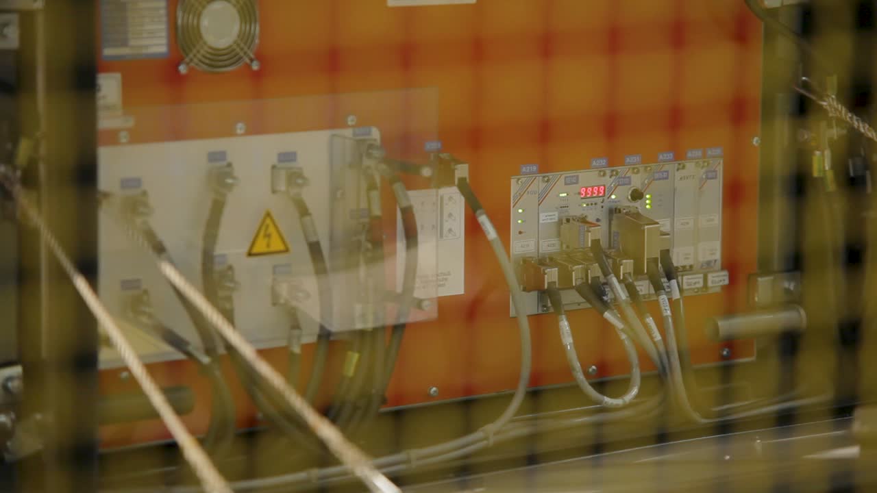 Close-up of industrial control panel with cables and warning signs, rack focus effect