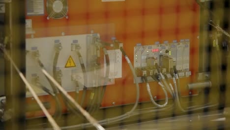 close-up of industrial control panel with cables and warning signs, rack focus effect
