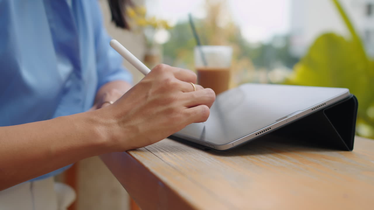 Hands of Sketcher Drawing on Tablet in Outdoor Cafe
