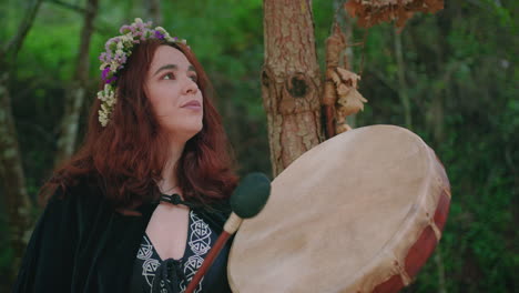 Niña-Druida-En-Un-Bosque-Tocando-Un-Tambor-Chamánico-Plano-Medio