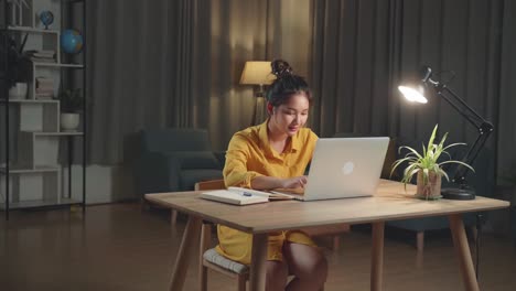 mujer joven trabajando en la computadora portátil por la noche