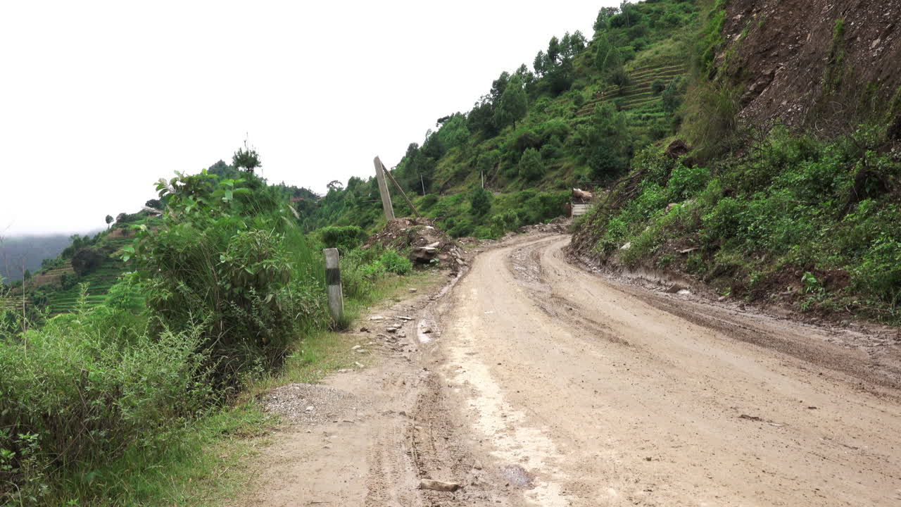 Kathmandu, Nepal - September 27, 2019: Traffic and vehicles on a dangerous, muddy mountain road in the foothills of Kathmandu, Nepal on September 27, 2019.