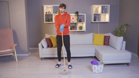 el hombre escucha música y baila durante las tareas domésticas.