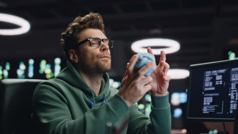 thoughtful man looking computer pondering project at dark datacenter closeup