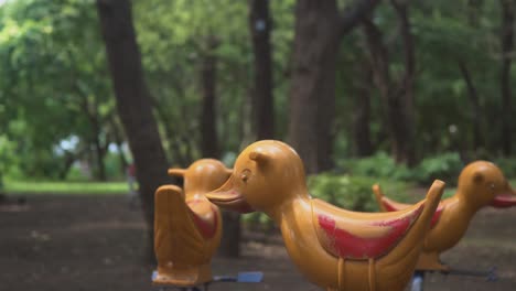 empty playground, moving merry go round with duck shaped seats