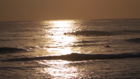 surfers waiting for waves at dusk - slomo