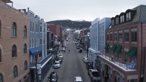 vista aérea de drones de main street, park city, utah, usa, que es una calle comercial con autos estacionados a ambos lados a través de la ciudad de montaña en una fría noche de invierno