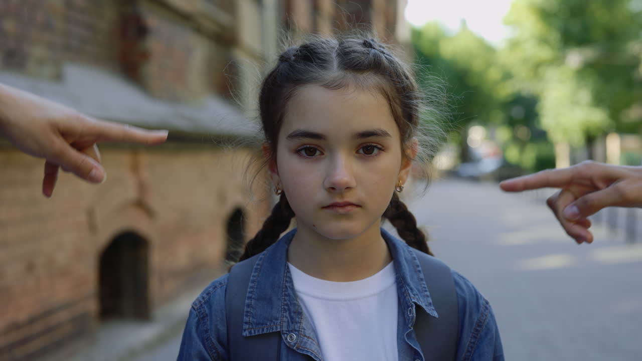 A young girl being pointed at by others