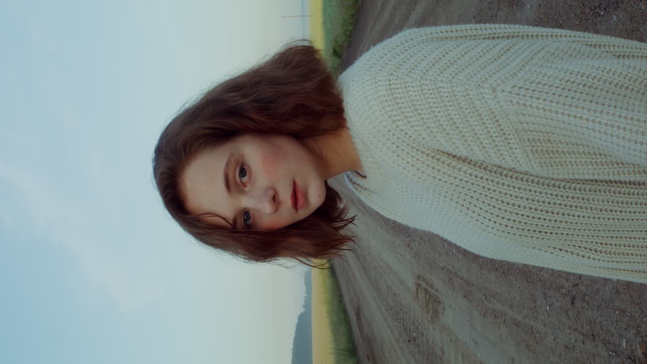 田舎の道路でベージュ色のスウェットを着た女性