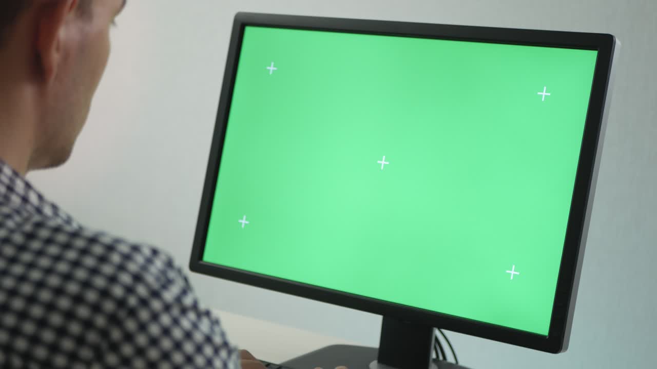 vista lateral en un hombre adulto mirando el monitor con pantalla de tecla de croma