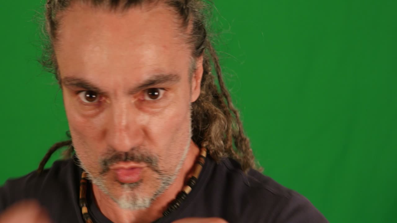 artista marcial haciendo entrenamiento de lucha aislado en el fondo de la pantalla verde. enérgico hombre rasta de mediana edad boxeando contra la cámara.