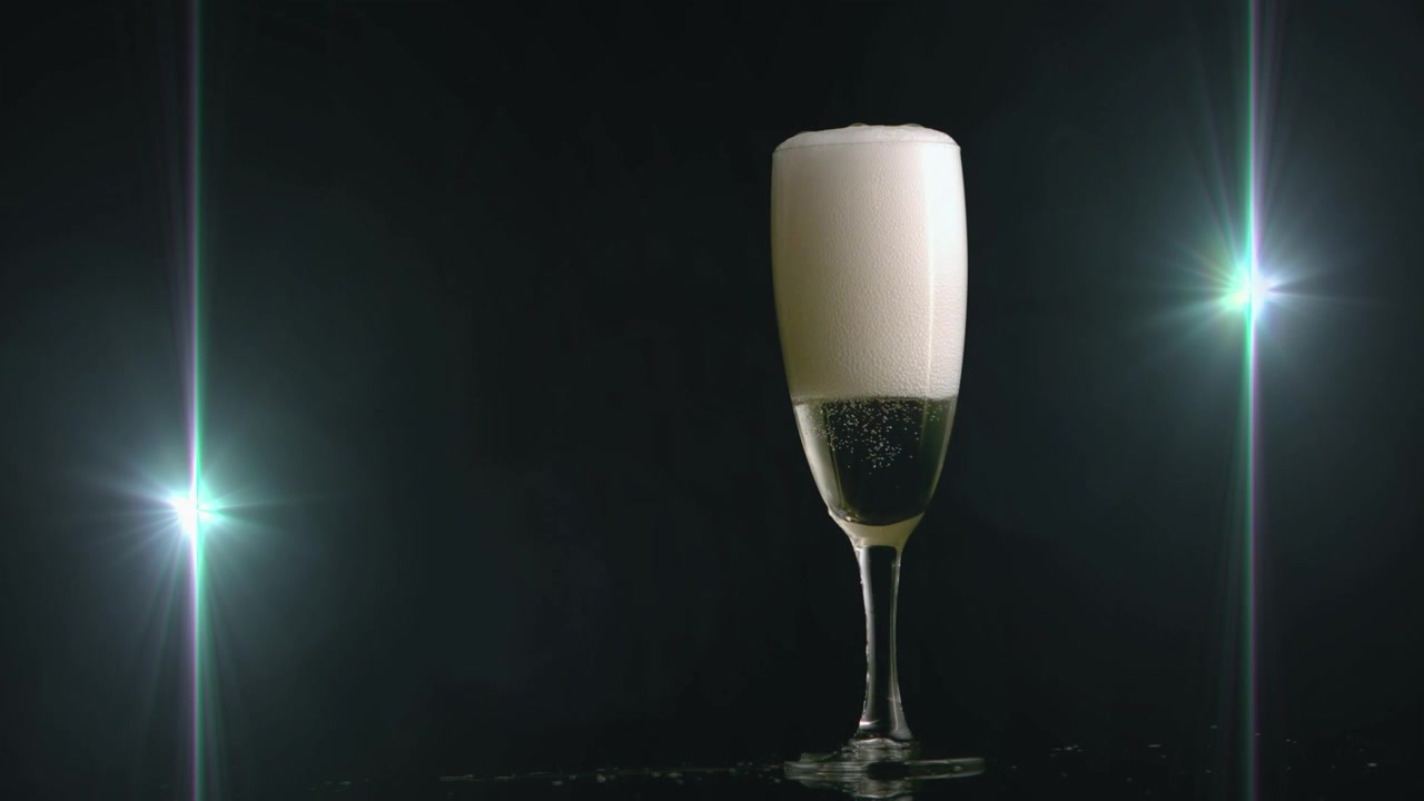 Verre à champagne devant deux points lumineux avec espace de copie sur fond noir