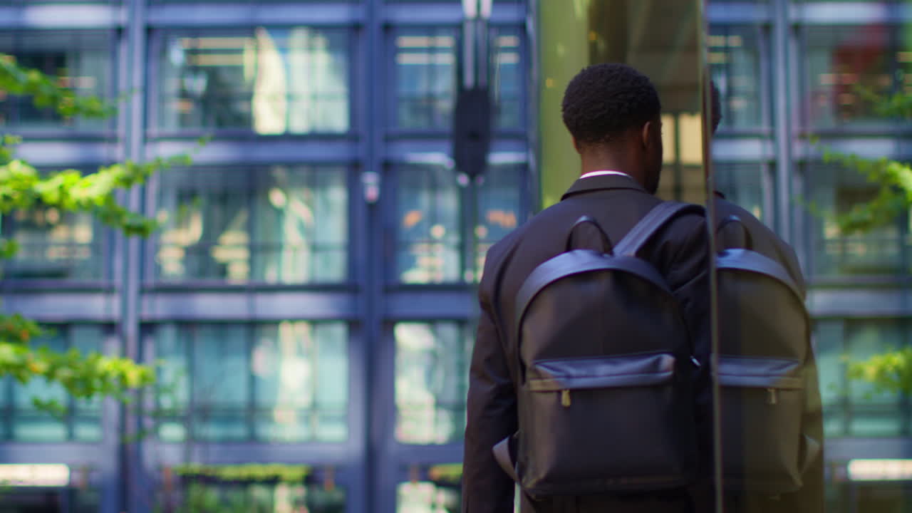 Rear View Of Businessman Wearing Backpack Walking To Work In Offices In The Financial District Of The City Of London UK