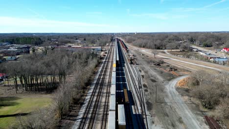 long straight railroad track with train and cars in salisbury, nc