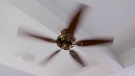 close up of fast spinning ceiling fan at home in white washed room