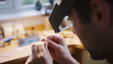 Primer-Plano-De-Un-Joyero-Masculino-Mirando-El-Anillo-A-Través-De-Lupas-En-La-Diadema-En-El-Estudio