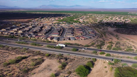 aerial reveal of car traffic on nogales highway with rancho sahuarita in background, arizona in usa