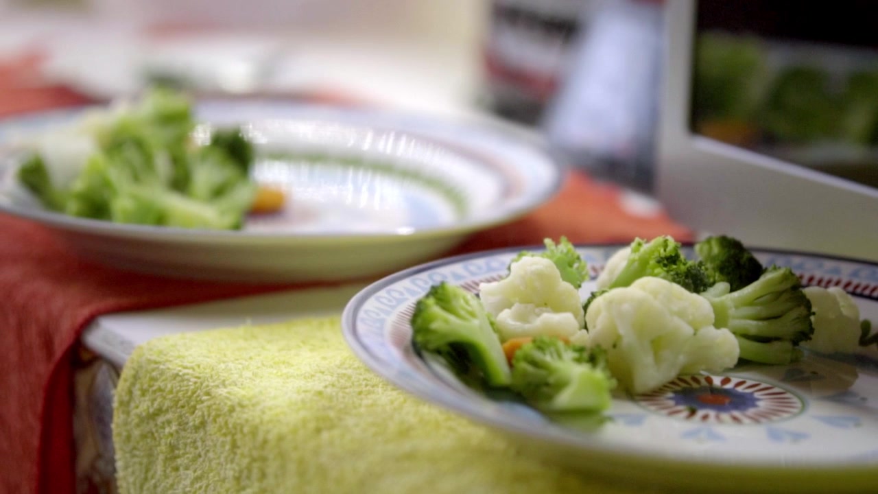 Primo piano di cimette di broccoli e cavolfiore al vapore servite su un piatto di ceramica, che evidenzia un contorno fresco e nutriente preparato per un pasto sano