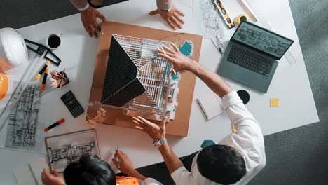 Top-down-view-of-skilled-team-using-pencil-measuring-house-model.-Alimentation.