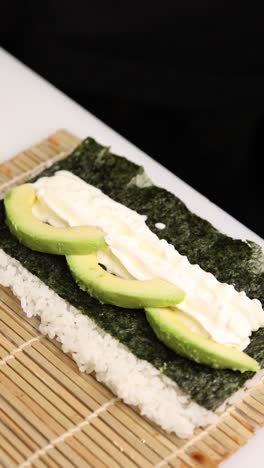 haciendo un rollo de sushi de aguacate