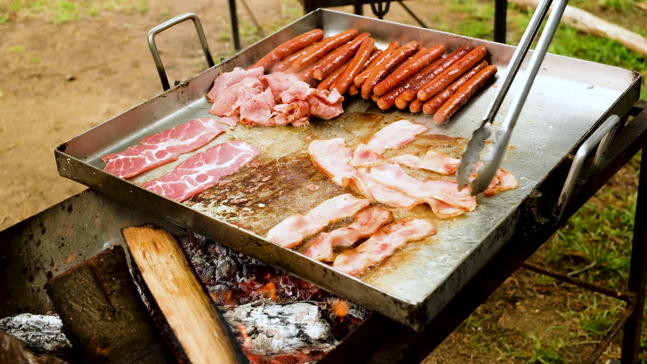 열린 불에 스테인레스 스틸 팬에 베이컨과 소시지 튀김 - 캠프 아침 식사