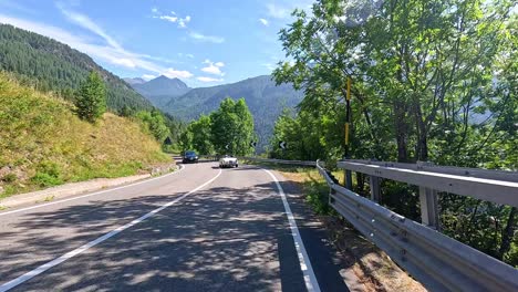 mountain road with cars and lush greenery