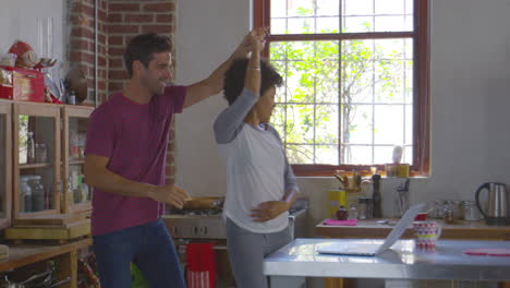 Una-Joven-Pareja-De-Raza-Mixta-Bailando-En-La-Cocina,-Filmada-En-R3d