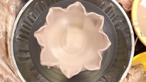 fantastic view of a flower shaped clayware spinning on the potter's wheel.