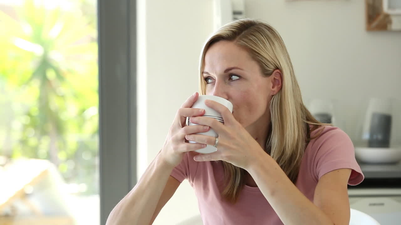 una mujer rubia disfrutando de su bebida.