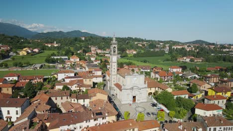 drone aéreo disparó sobre una catedral y una ciudad con el cielo azul en el horizonte en pagnano, lombardía, italia