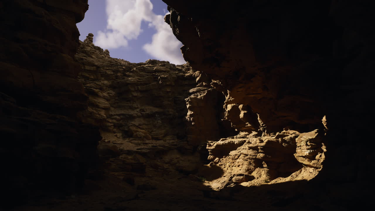 Natural rock formations create dramatic light in a canyon at midday